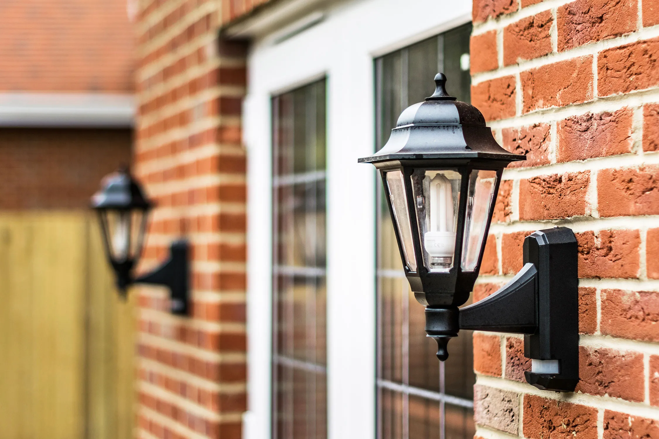 Light hung up on brick wall outside house
